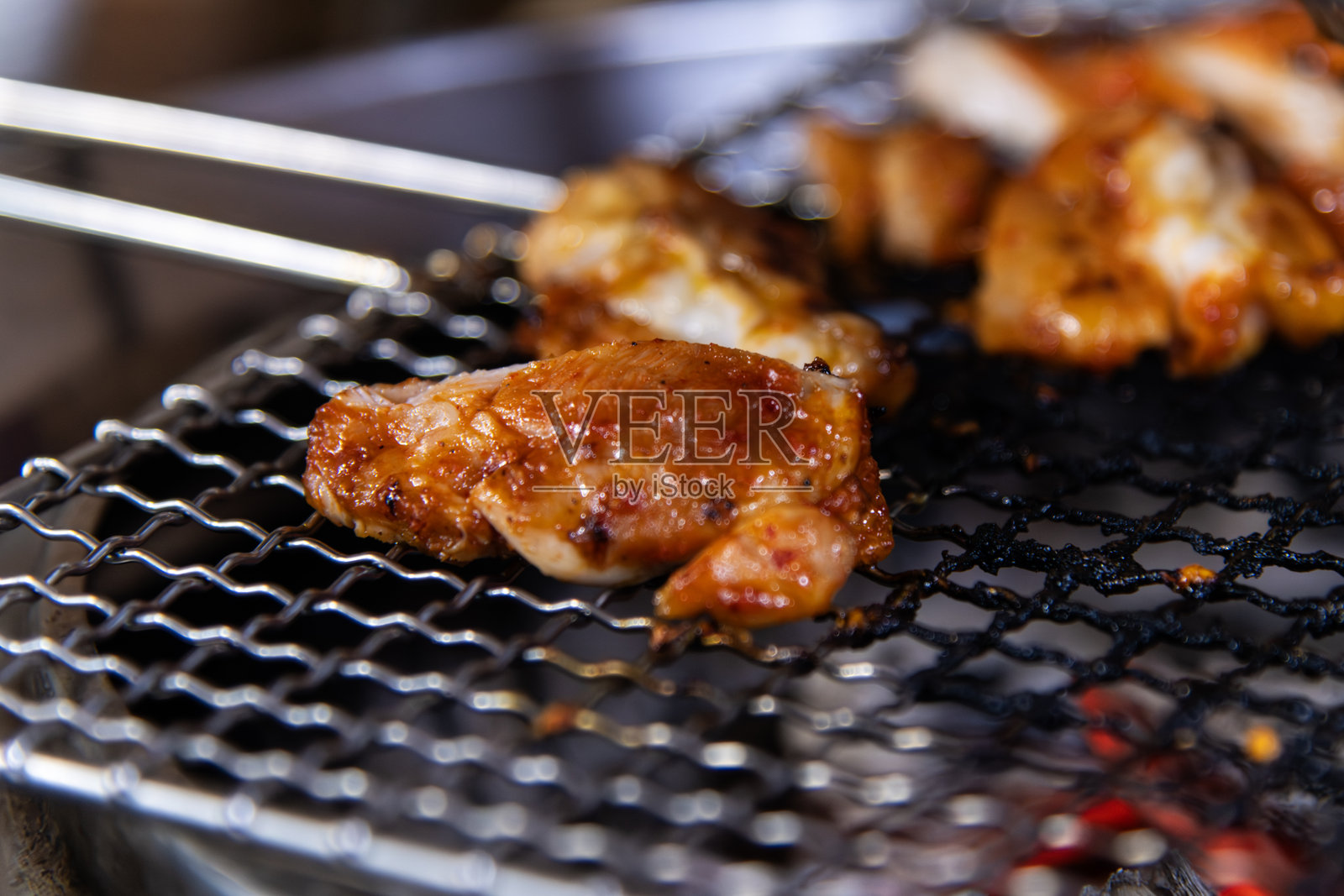 在炭火上烤制辣味腌制鸡肉照片摄影图片