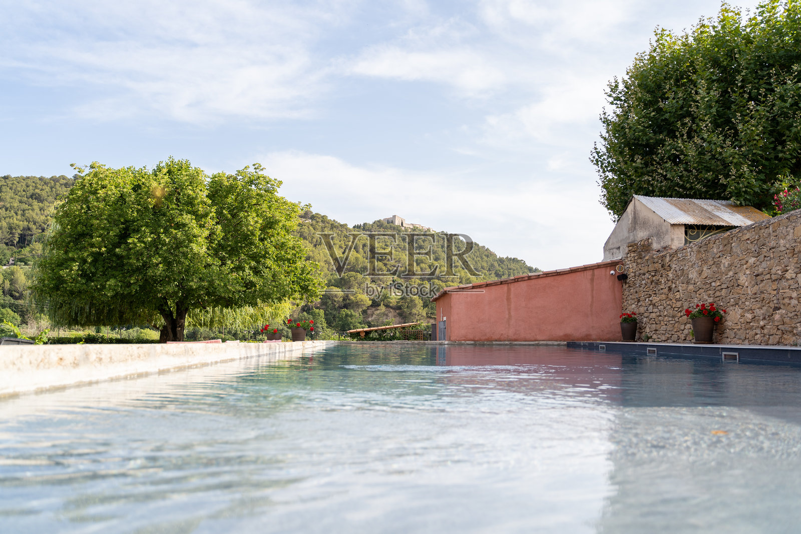 宁静的户外逃离，泳池景色与山丘、树木和湛蓝的天空相映成趣照片摄影图片