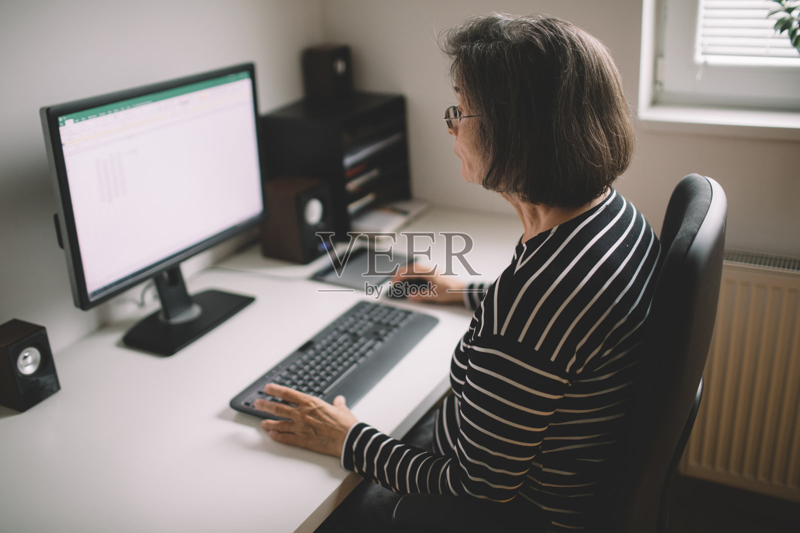 一位年长女性在网上自由职业工作照片摄影图片