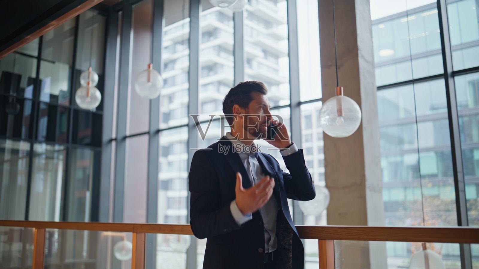 企业董事在豪华办公室大堂内近距离使用手机。照片摄影图片