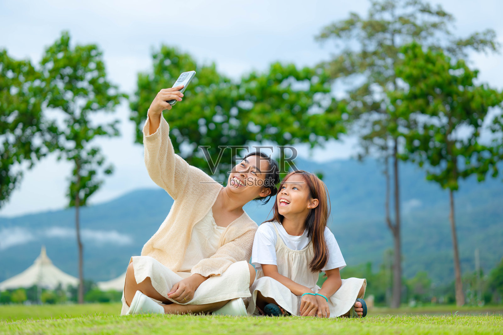 快乐的母女在春天的公园里共度时光。照片摄影图片