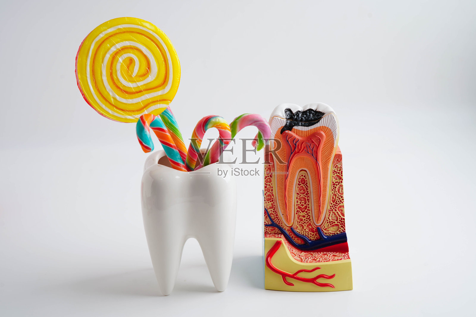 牙齿腐烂与甜蜜的糖果，牙齿健康的坏食物。照片摄影图片