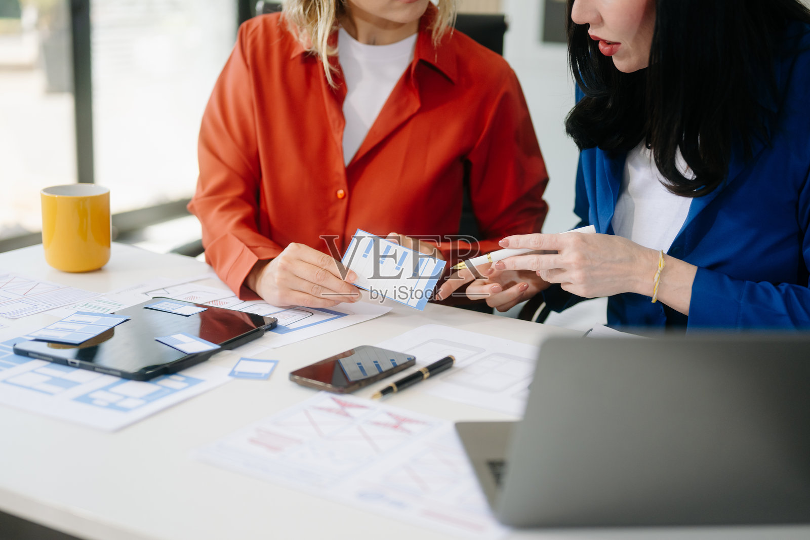 UX开发者和UI设计师正在头脑风暴移动应用界面线框设计。照片摄影图片