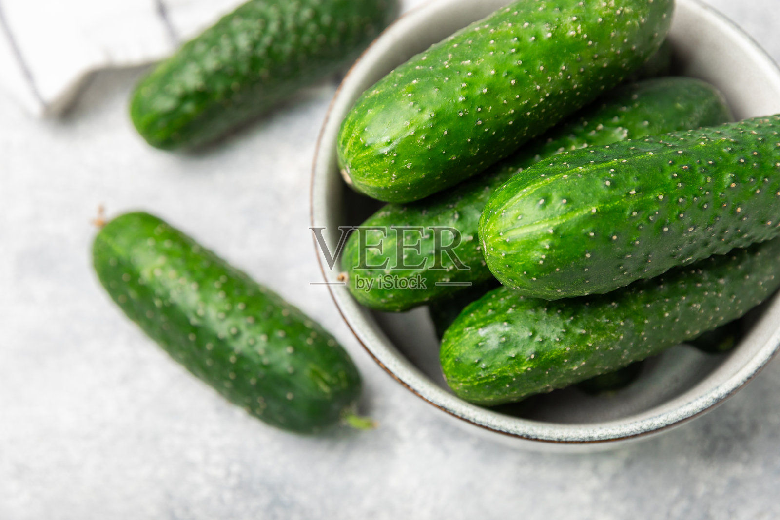 木质背景上的黄瓜。背景上的黄瓜切片。新鲜有机绿色小黄瓜。素食。沙拉配料。农场蔬菜。用刀切的蔬菜。留白空间。照片摄影图片