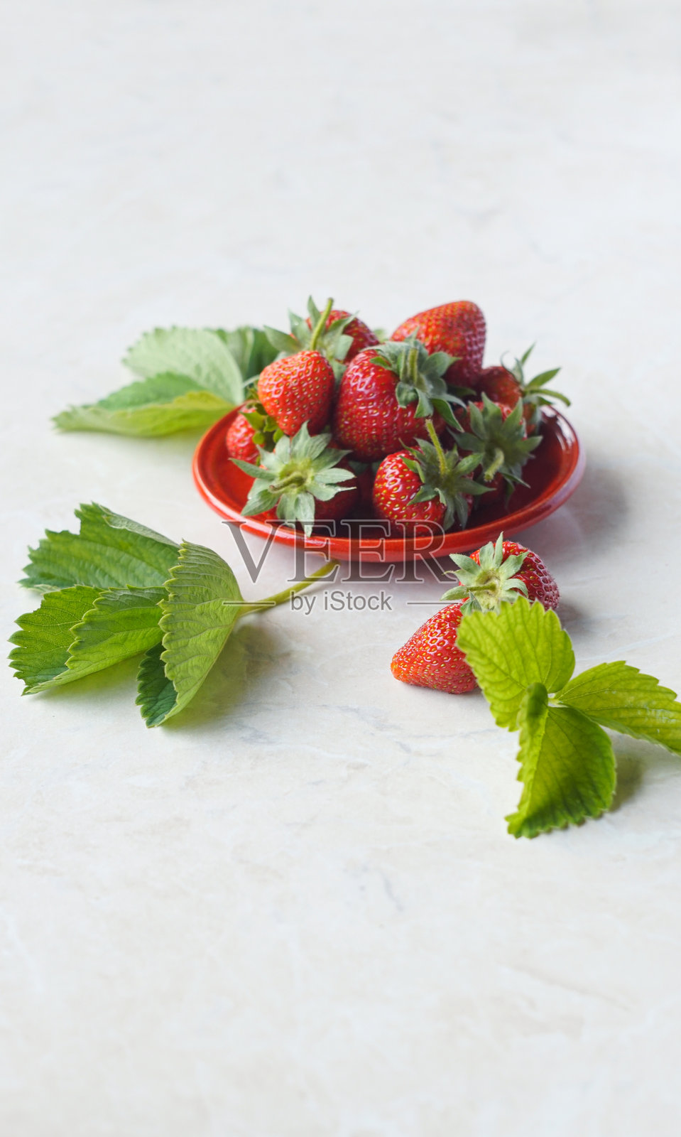 白色背景上的碗里装着草莓照片摄影图片
