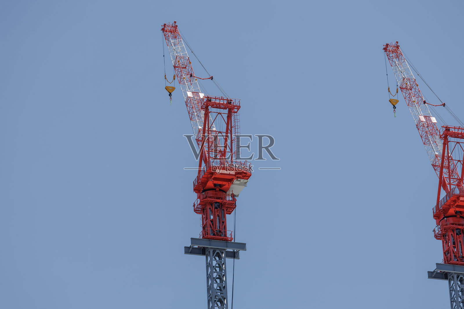 城市环境中清澈蓝天下的红色建筑起重机照片摄影图片