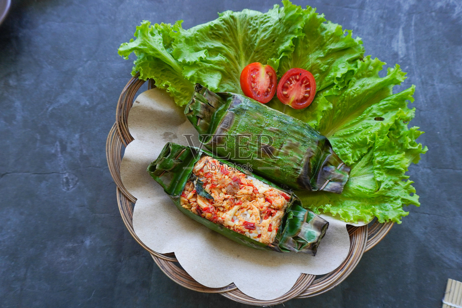 烤饭是印尼美食，用香蕉叶包裹米饭后烤制。米饭中填充香料、辣椒酱、 shredded 鸡肉、肉类或鱼类。照片摄影图片