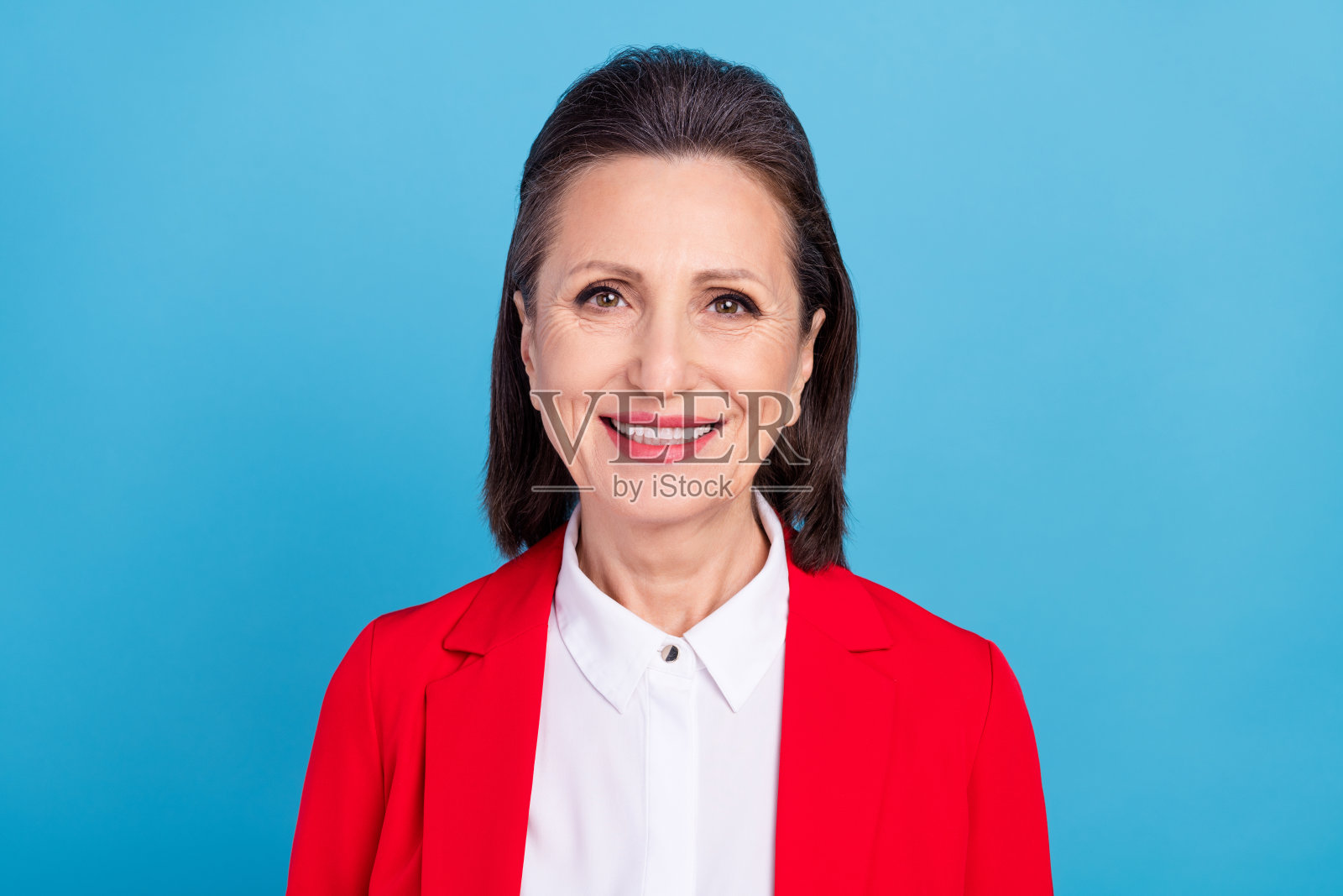 迷人、快乐、聪明的女性商业人士，人力资源执行董事，背景为明亮的蓝色。照片摄影图片