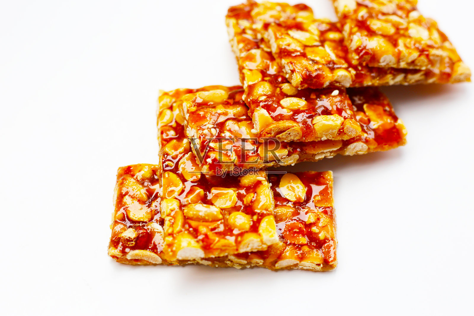 光滑焦糖包裹的脆皮花生糖棒。照片摄影图片