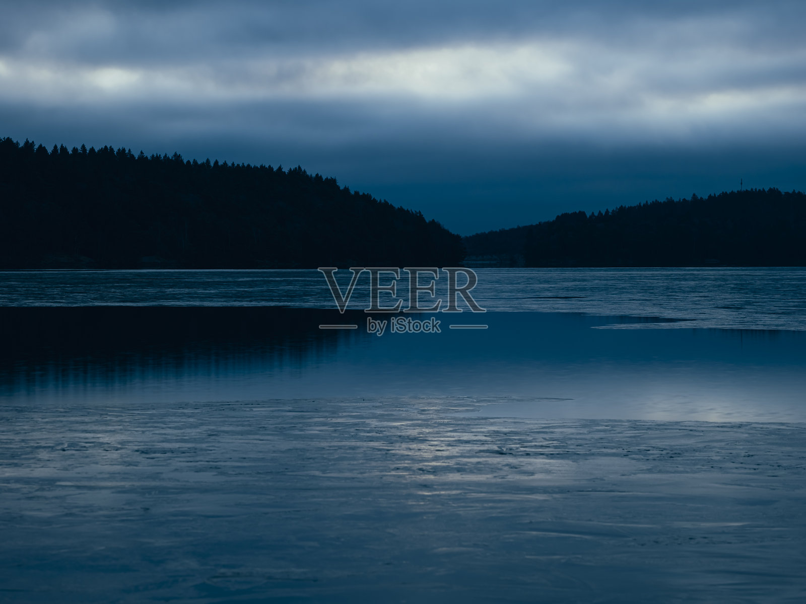 哥德堡附近的冰冻湖泊在黄昏时分展现出宁静的冬季之美和柔和的蓝色调照片摄影图片