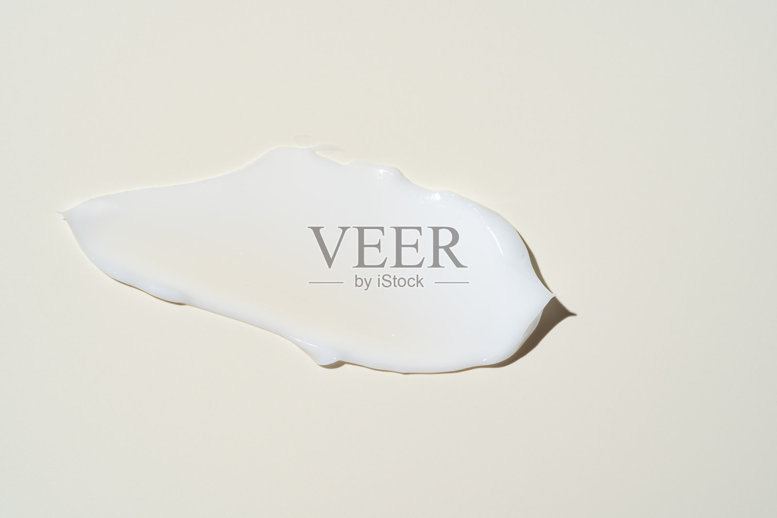 奢华的面霜涂抹并融合在中性色表面上，突显出润肤霜广告中的顺滑涂抹效果。照片摄影图片