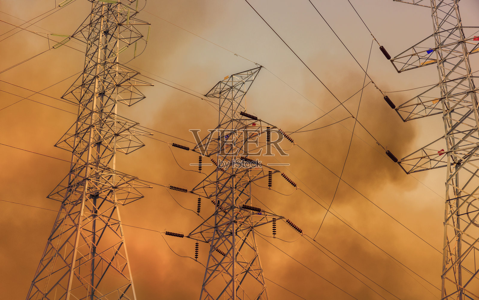 野火在电力输送塔线附近燃烧。照片摄影图片