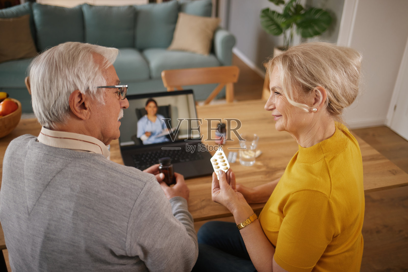 老年夫妇在家通过视频通话与医生讨论药物事宜照片摄影图片