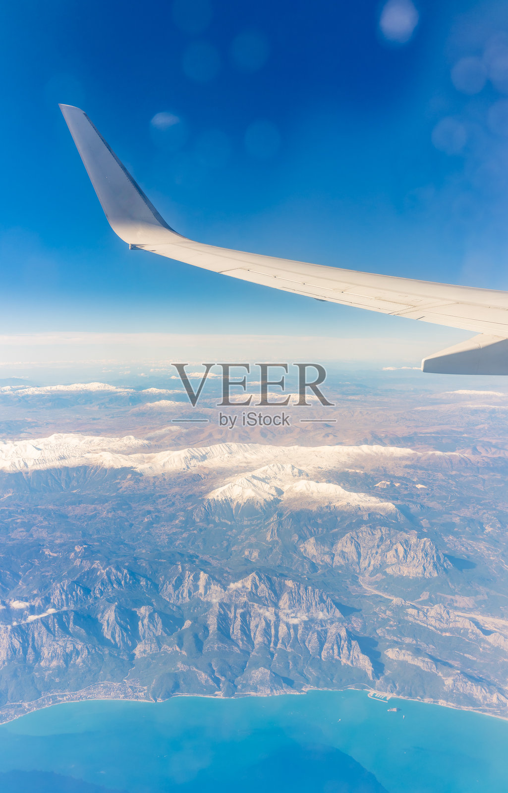 从飞机窗户看到的埃及沙姆沙伊赫的山脉和海滨度假村，海中有珊瑚。照片摄影图片