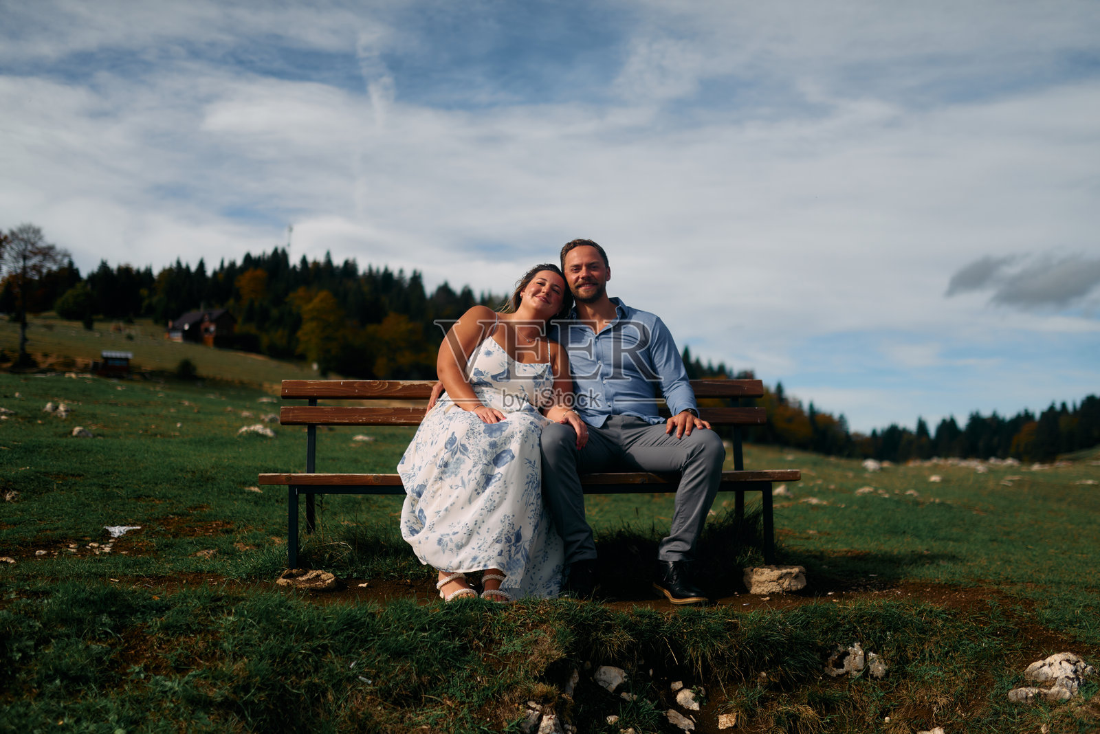 一对情侣坐在山景长椅上照片摄影图片