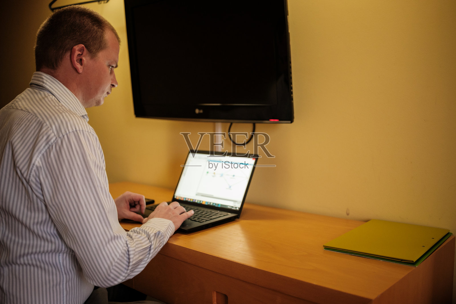 商人在酒店房间内使用笔记本电脑工作照片摄影图片