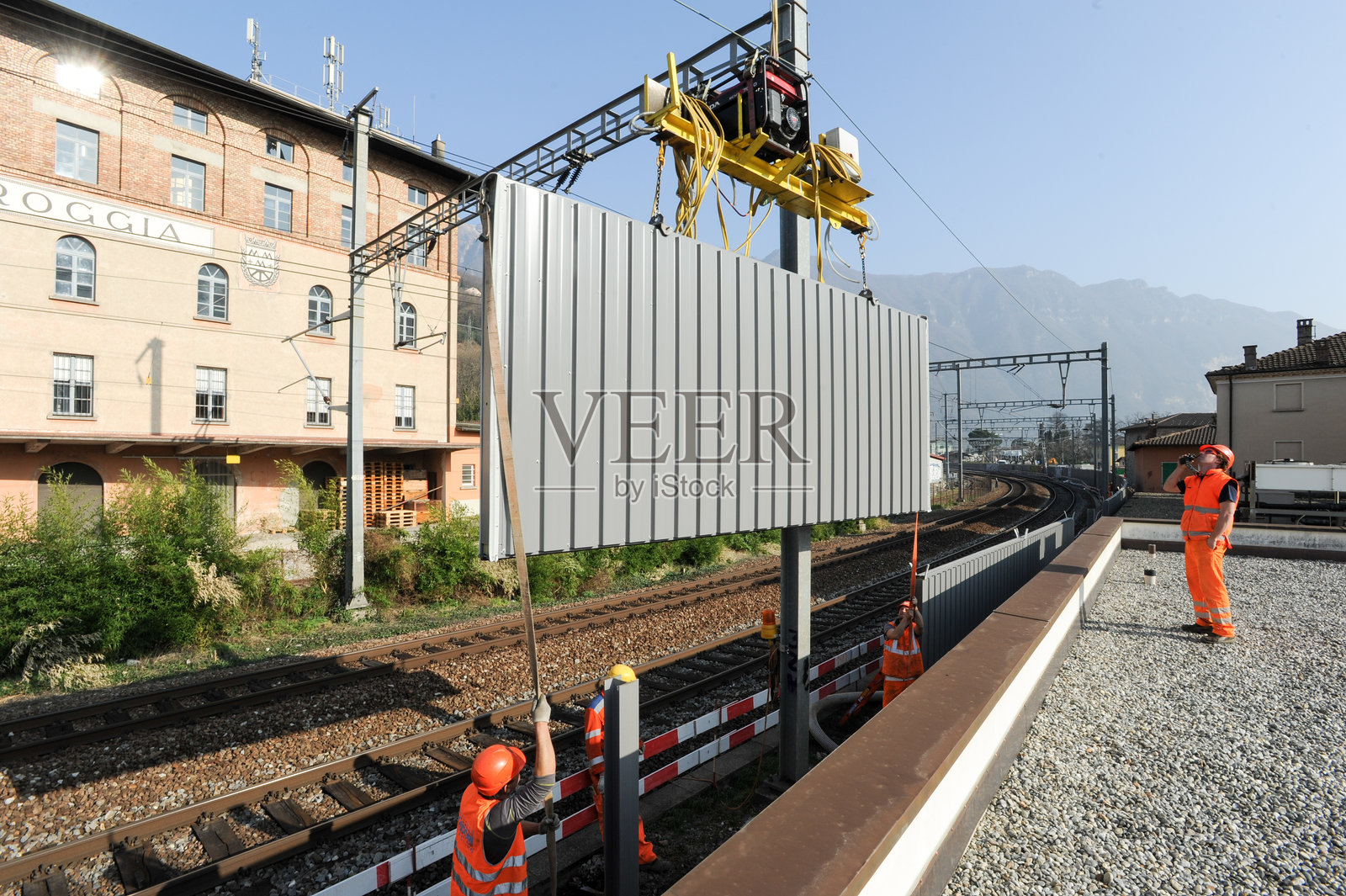 工人在铁路上安装隔音屏障照片摄影图片