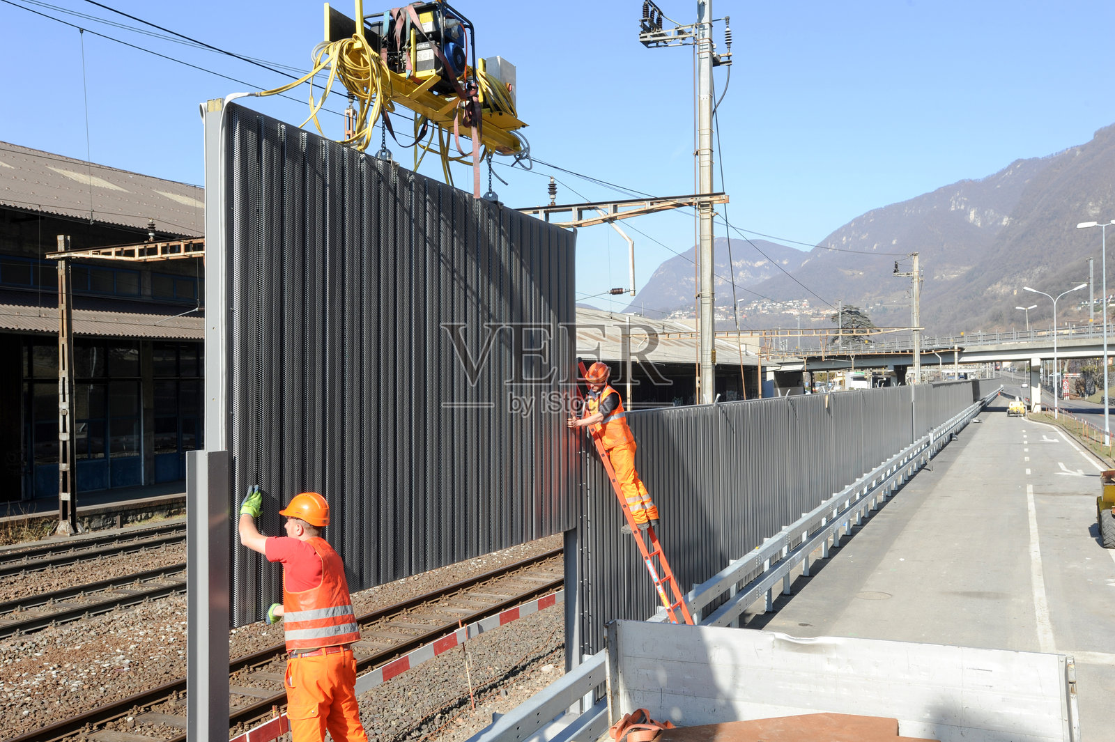 工人在铁路上安装隔音屏障照片摄影图片