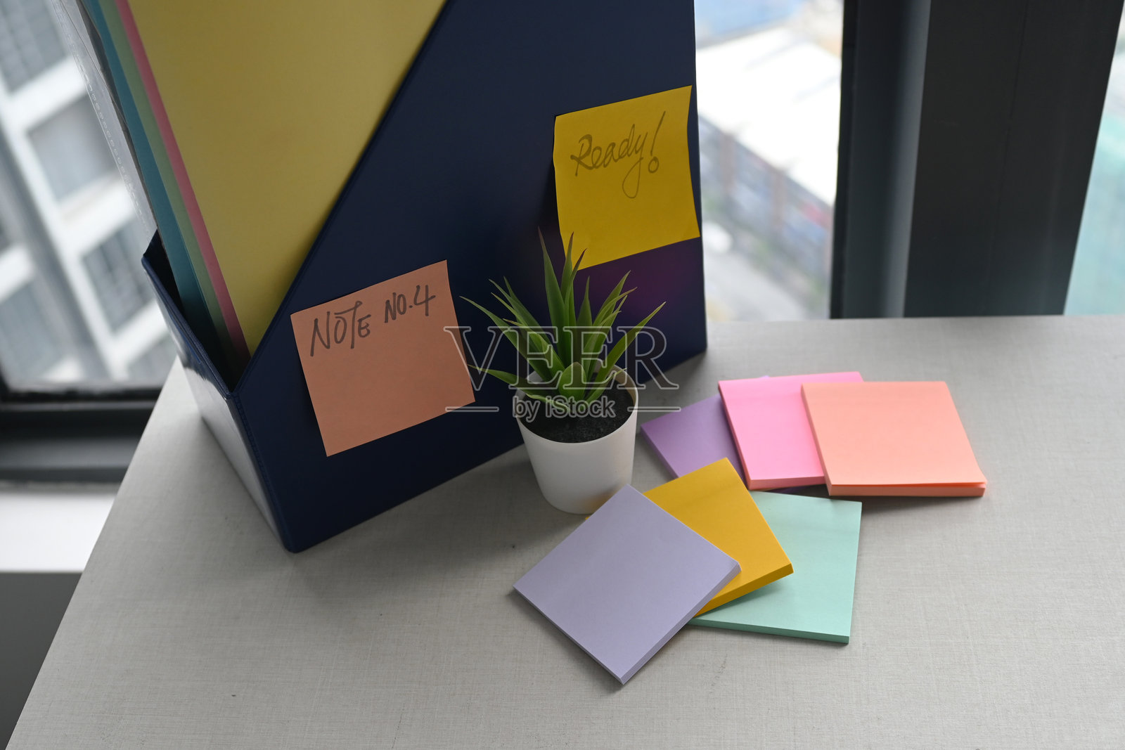 一堆五颜六色的粘性便签纸放在木质办公桌上。照片摄影图片