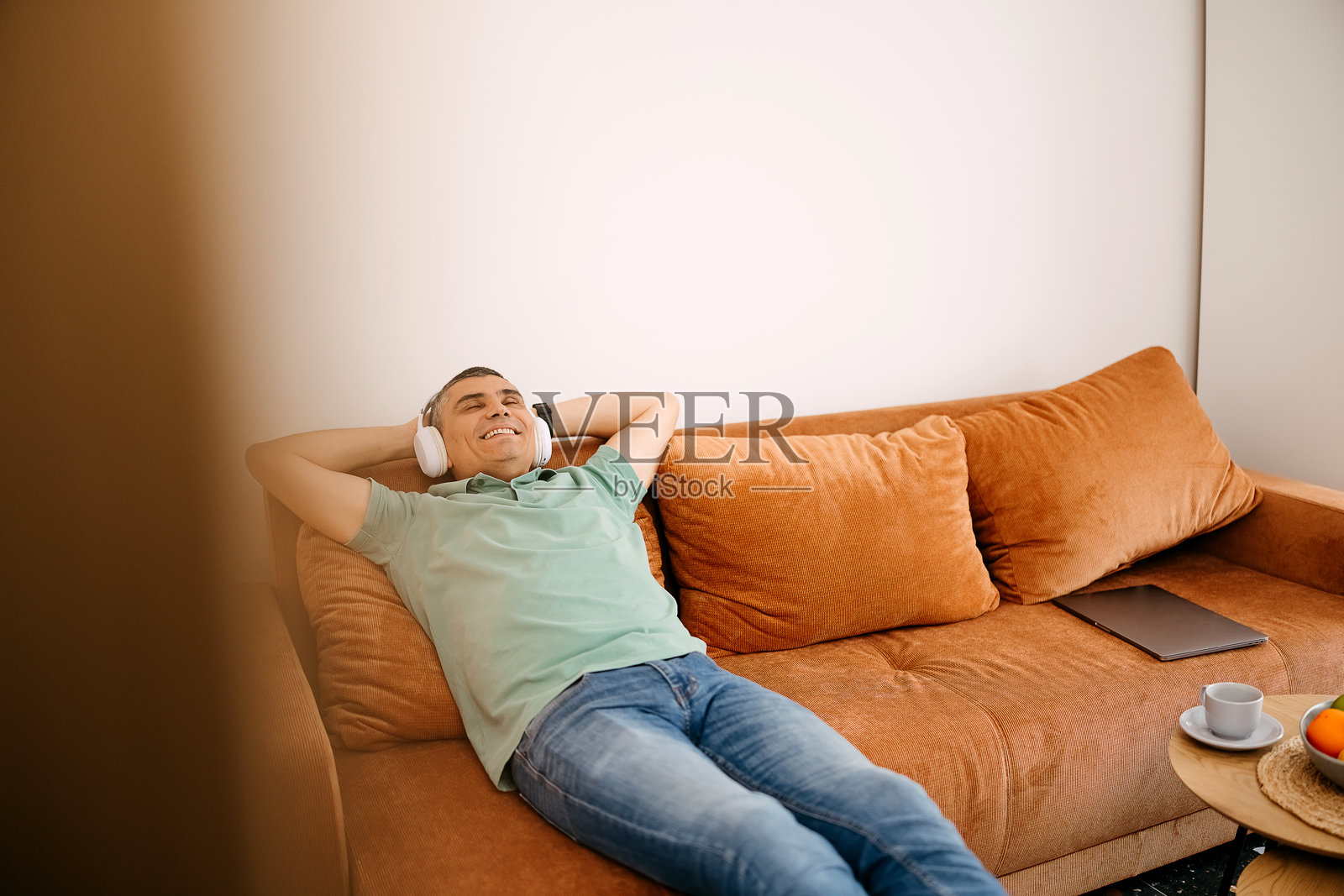 男人在客厅的沙发上放松。照片摄影图片