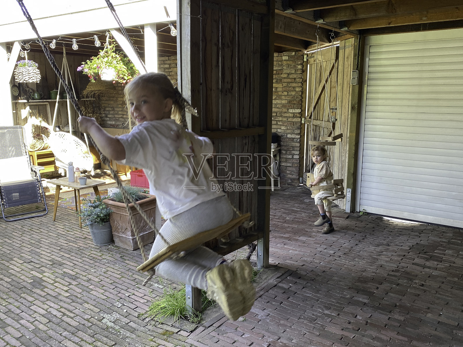 孩子们在秋千上玩耍照片摄影图片