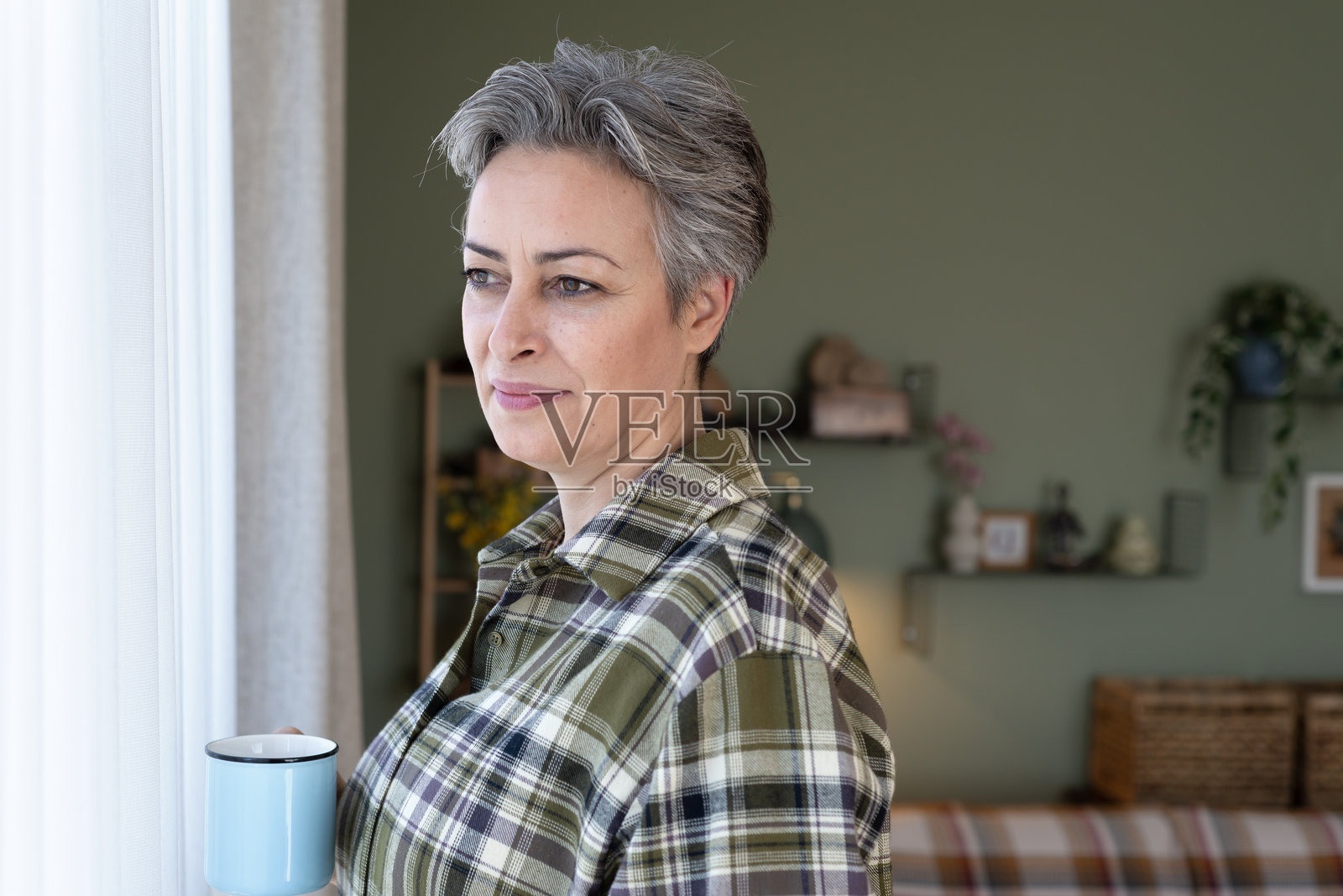 成熟的女性在家中站着手持咖啡杯的肖像照片摄影图片