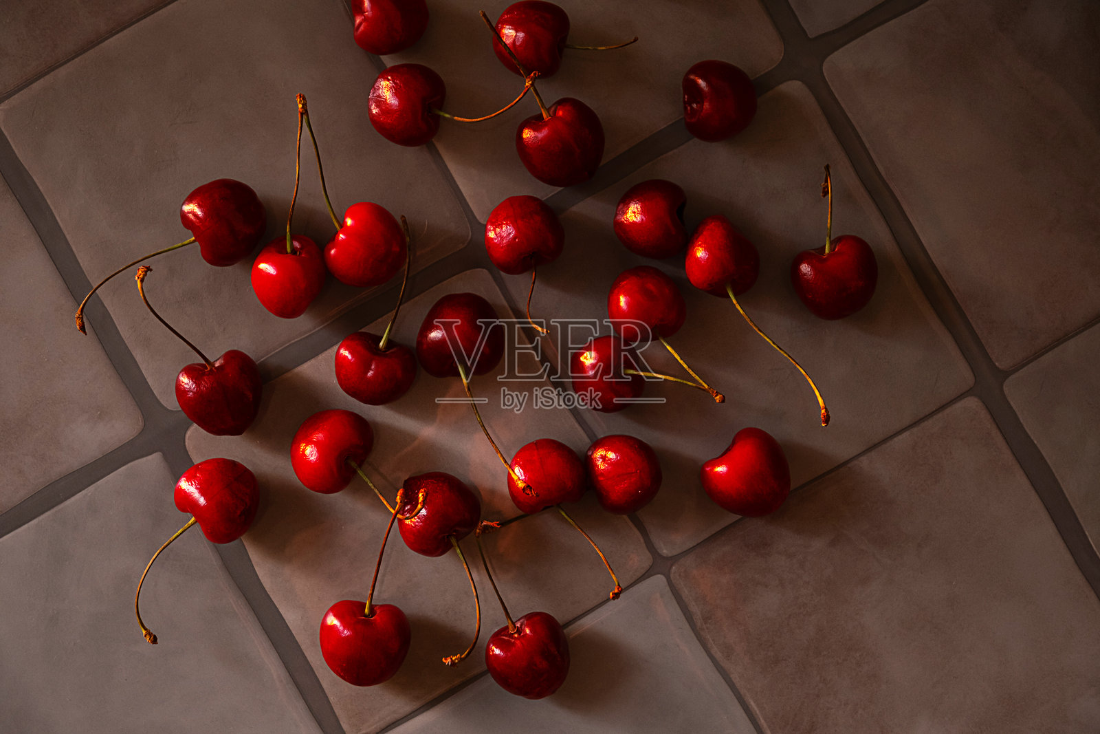 许多新鲜的深红樱桃在灰色瓷砖背景上。成熟的浆果水果。健康饮食和夏季甜点。照片摄影图片