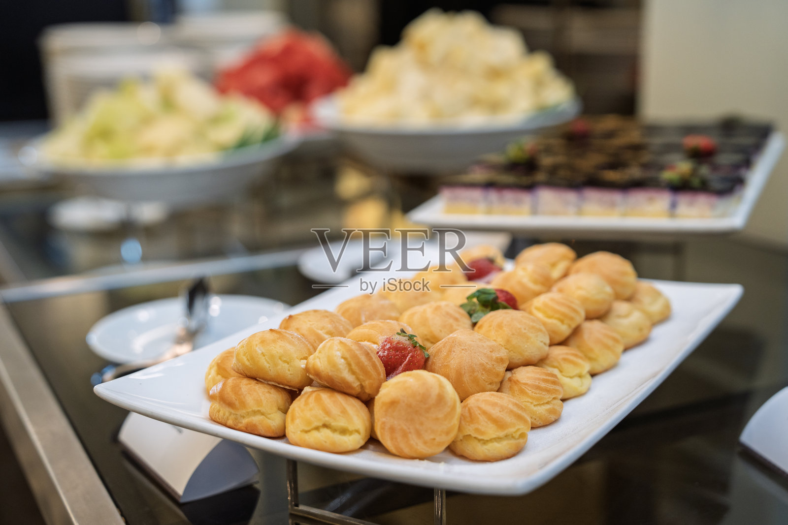 奶油泡芙摆放在自助餐甜点桌上照片摄影图片