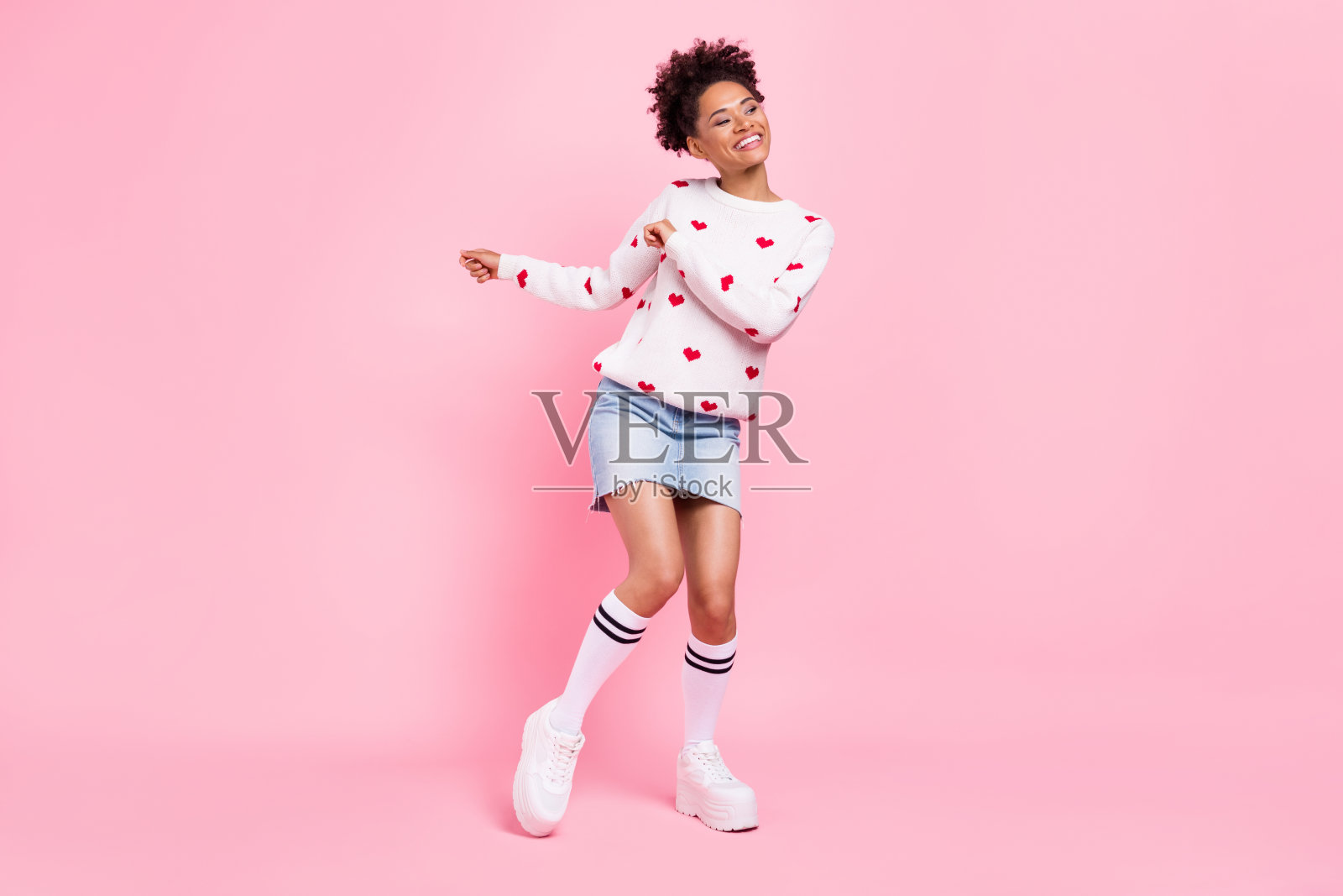 穿着白色毛衣的可爱非洲女士在蓝色背景下跳舞微笑的照片照片摄影图片