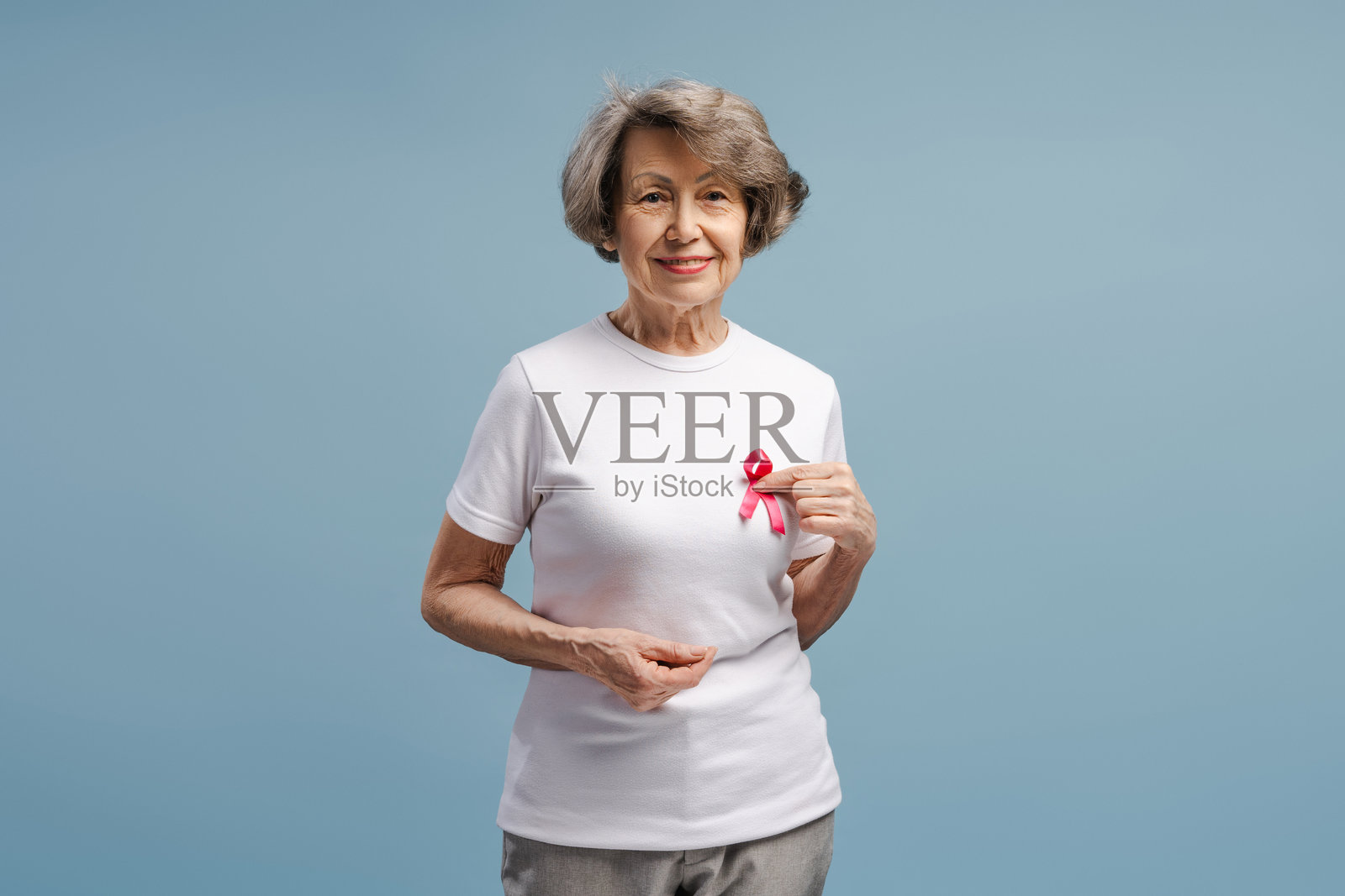 老年女性展示粉红丝带以支持乳腺癌意识活动照片摄影图片