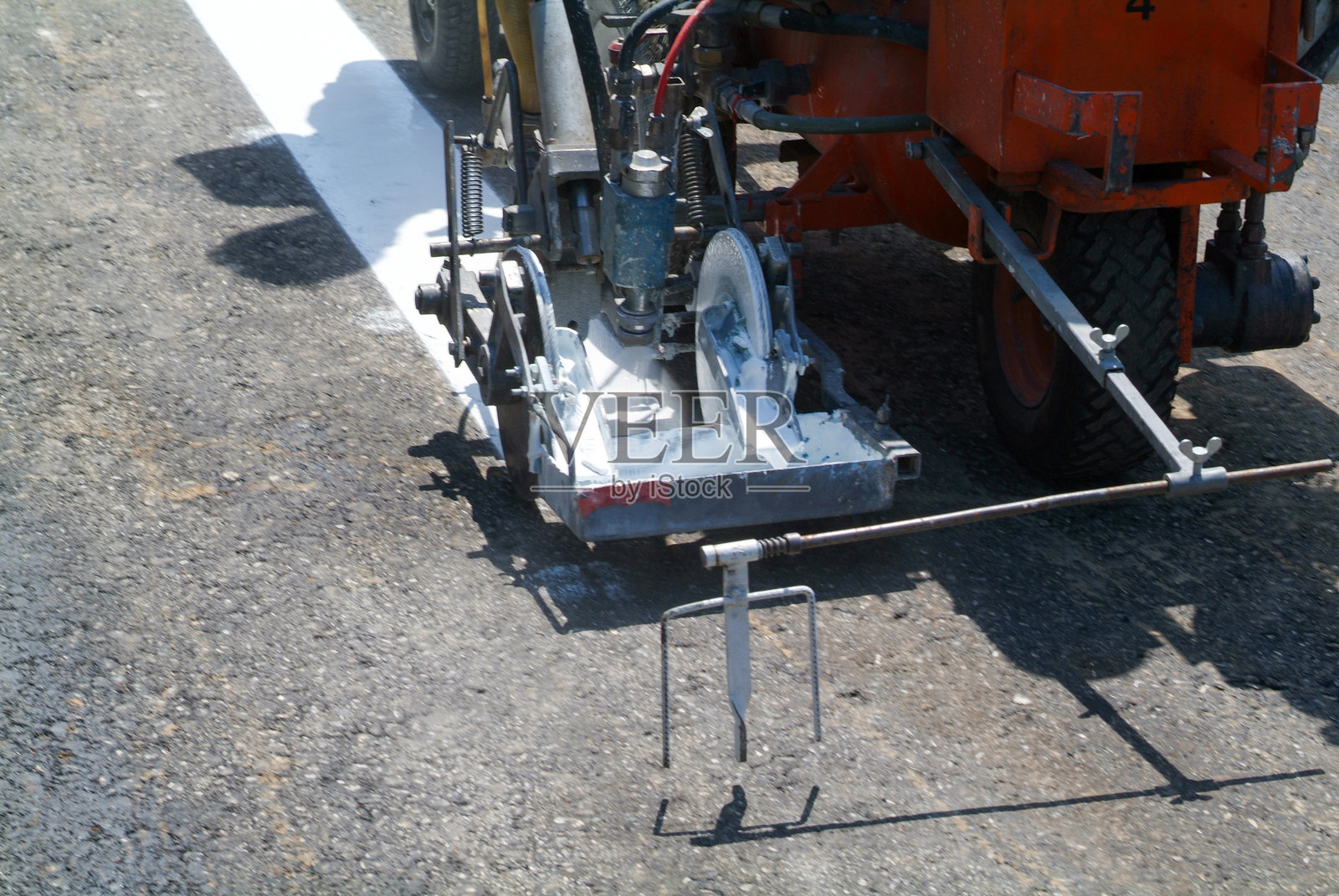 机器喷涂机和工人在道路上绘制交通标志照片摄影图片