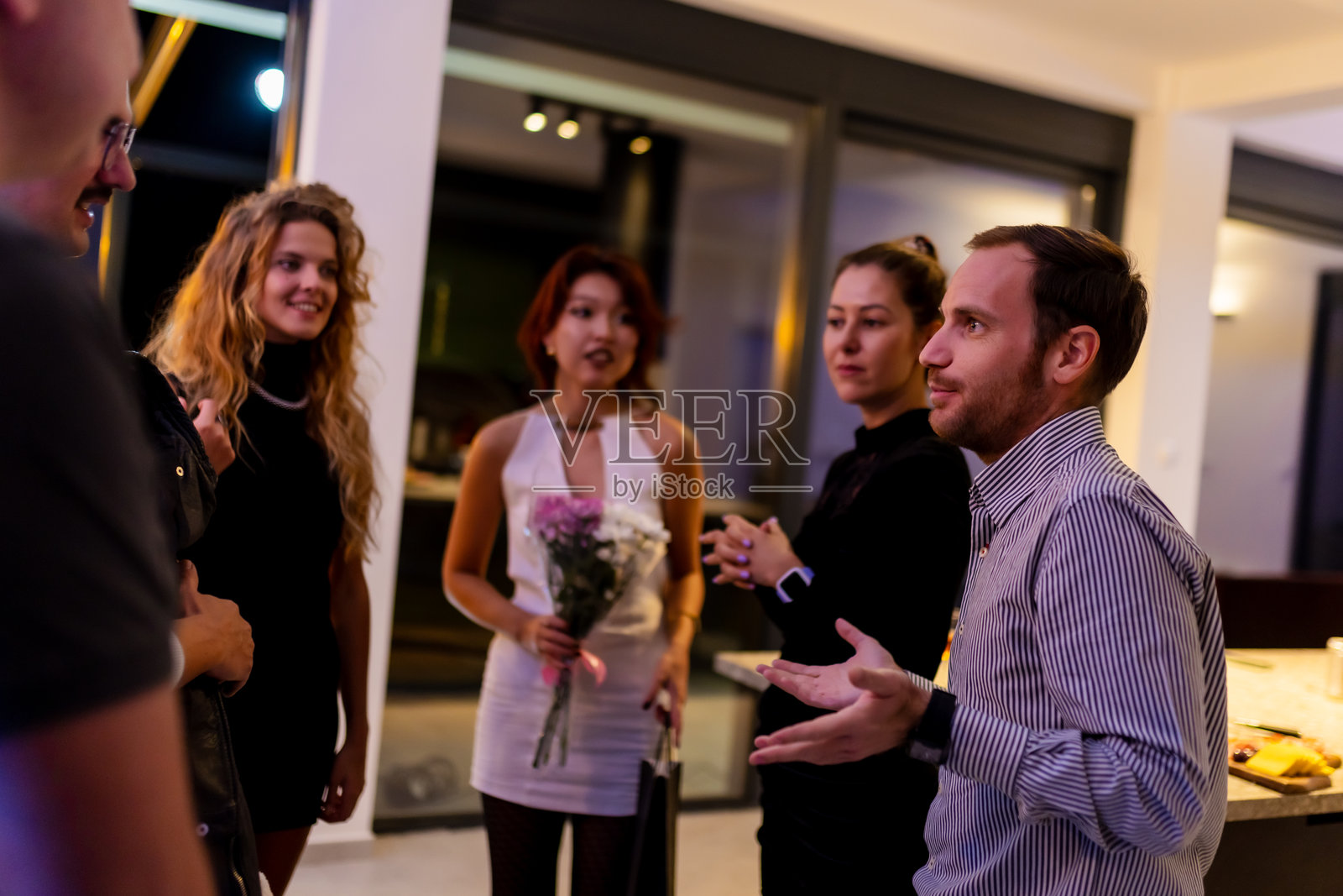 一群人在现代室内聚会上友好地交谈照片摄影图片