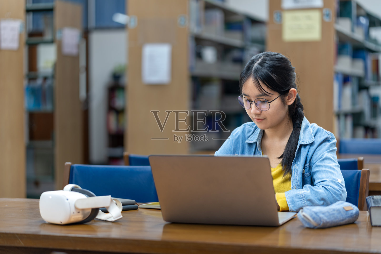 学生在图书馆环境中使用笔记本电脑学习照片摄影图片