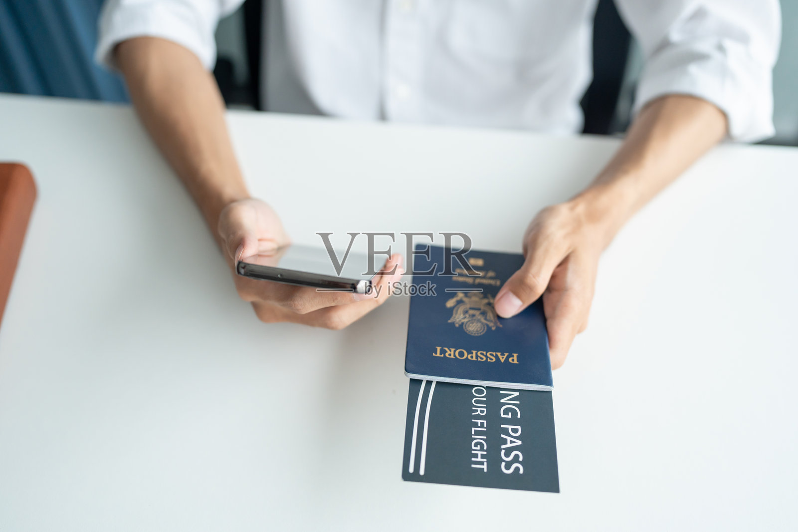 使用笔记本电脑、手机和信用卡在线预订和购买机票的男子，规划旅行度假，手中握有护照和机票。照片摄影图片