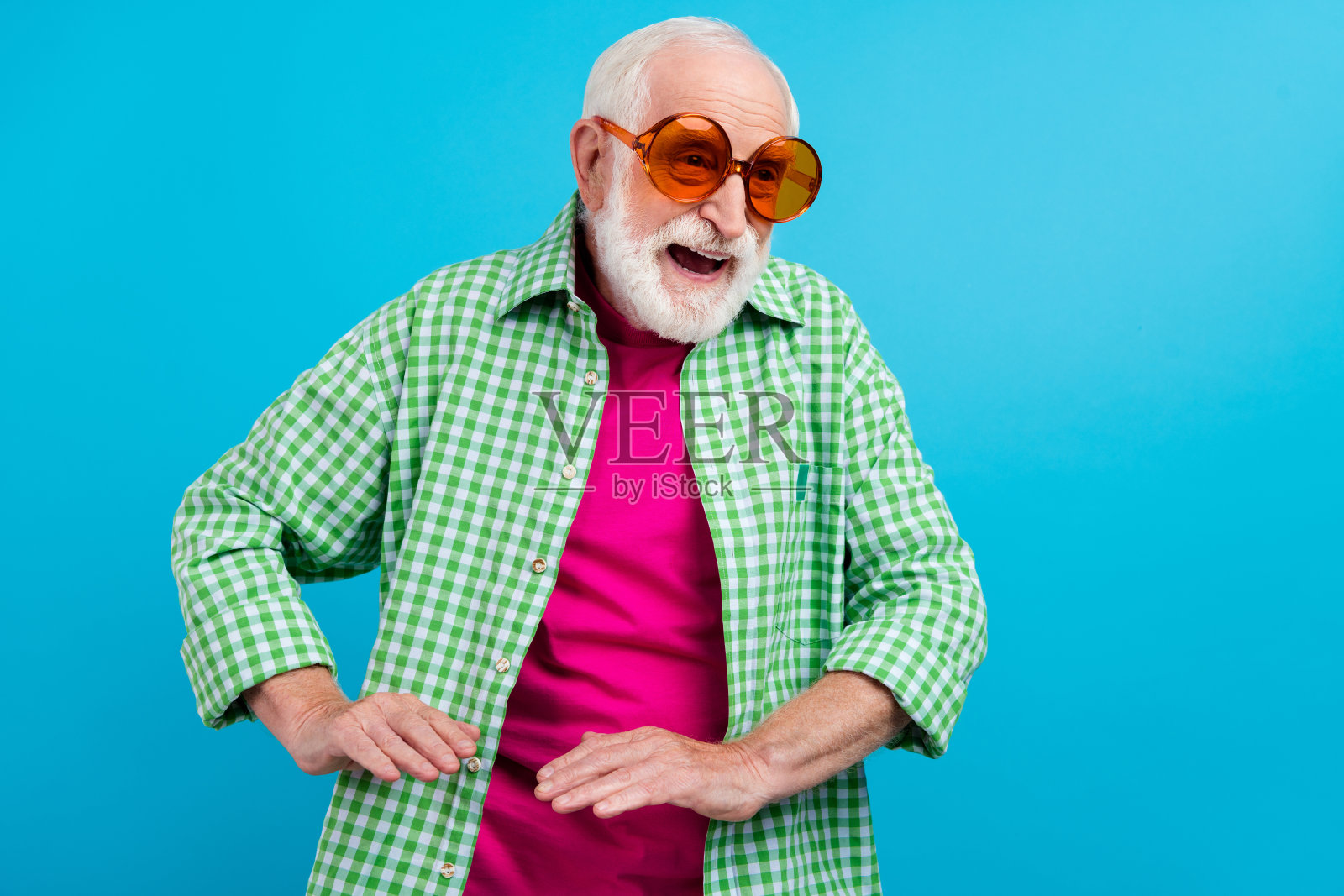 快乐的老年祖父母戴着太阳镜，享受夏季假期，背景为蓝色。照片摄影图片