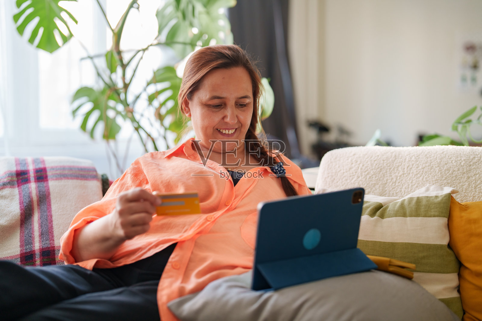 女性在平板电脑上使用信用卡进行在线购物照片摄影图片
