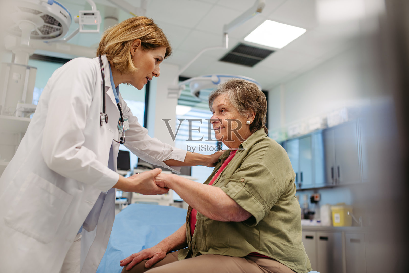 温柔地用手触碰安慰老年患者的和蔼医生照片摄影图片