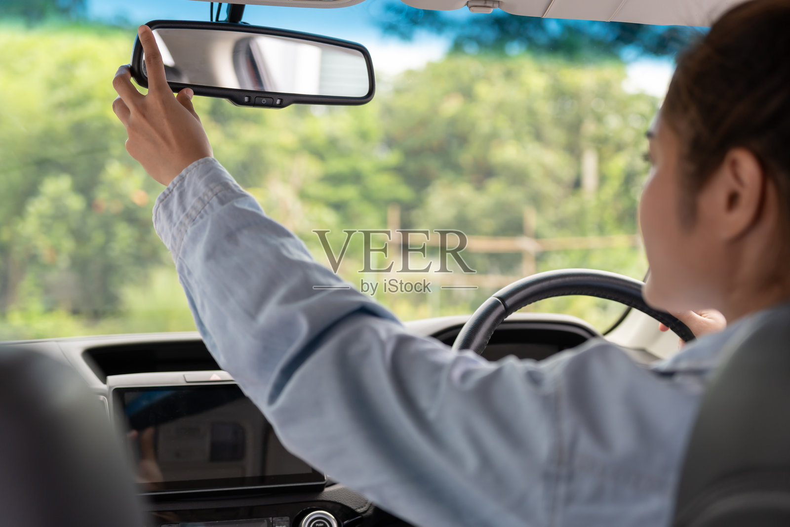 女性在开车前调整后视镜，专注驾驶，安全驾驶，驾驶练习，愉快的女性自信地坐在驾驶座上，准备好开始旅程。照片摄影图片