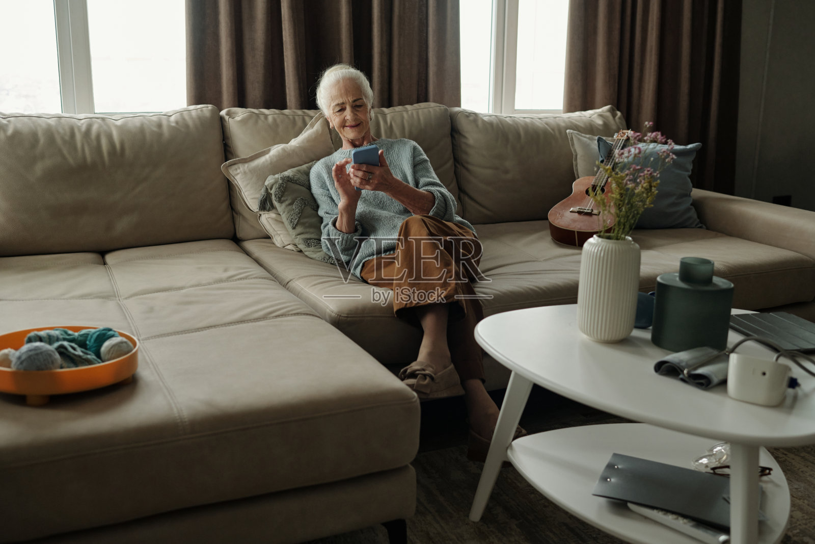 老年人坐在沙发上拿着手机照片摄影图片