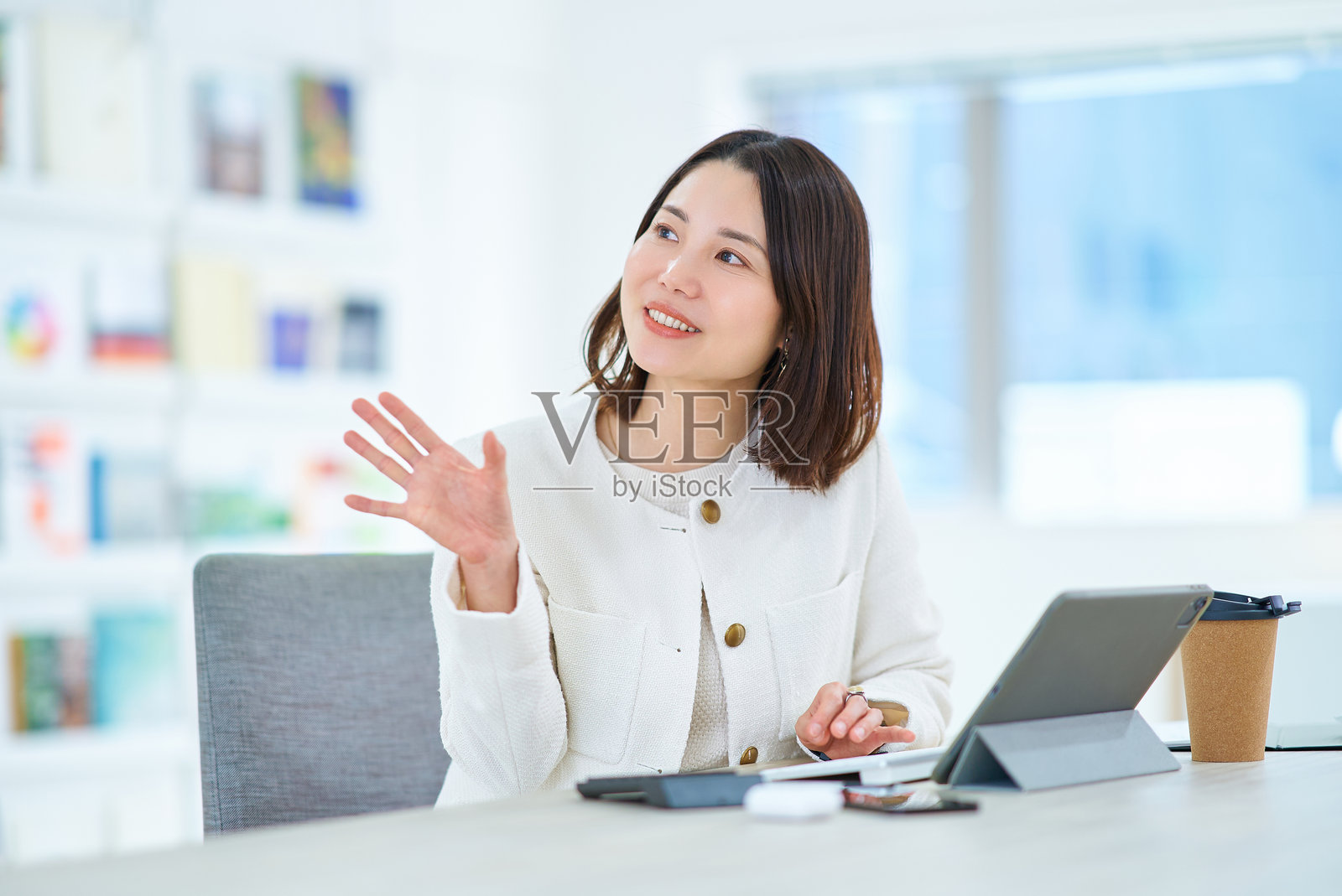 一位女性在工作中与同事交谈照片摄影图片