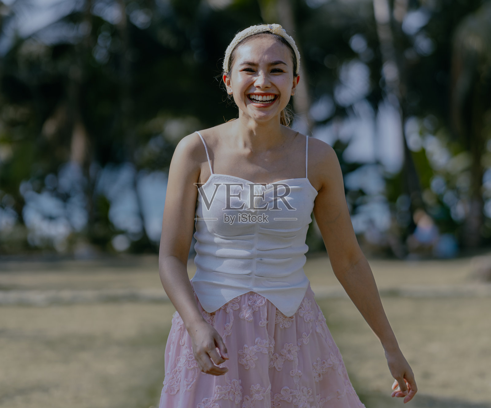 夏季户外，背景是树木和天空，微笑的亚洲女性肖像。照片摄影图片