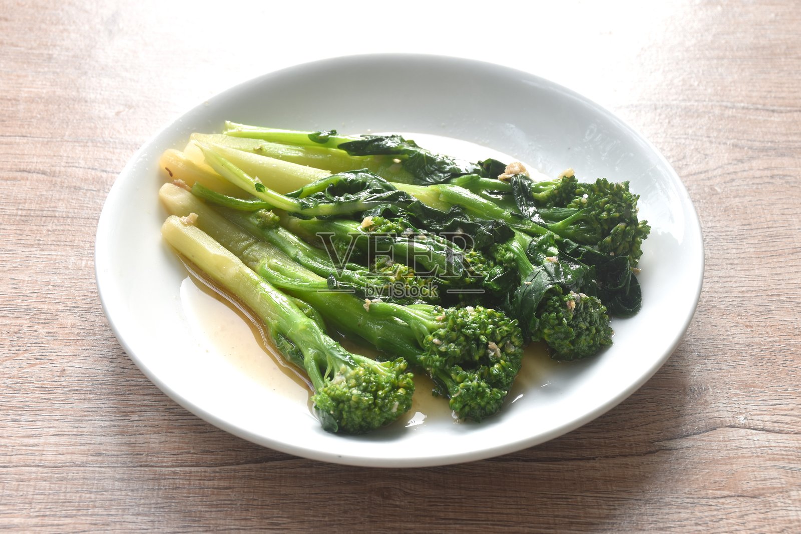 炒芥兰配蚝油、蒜蓉和咸鱼照片摄影图片