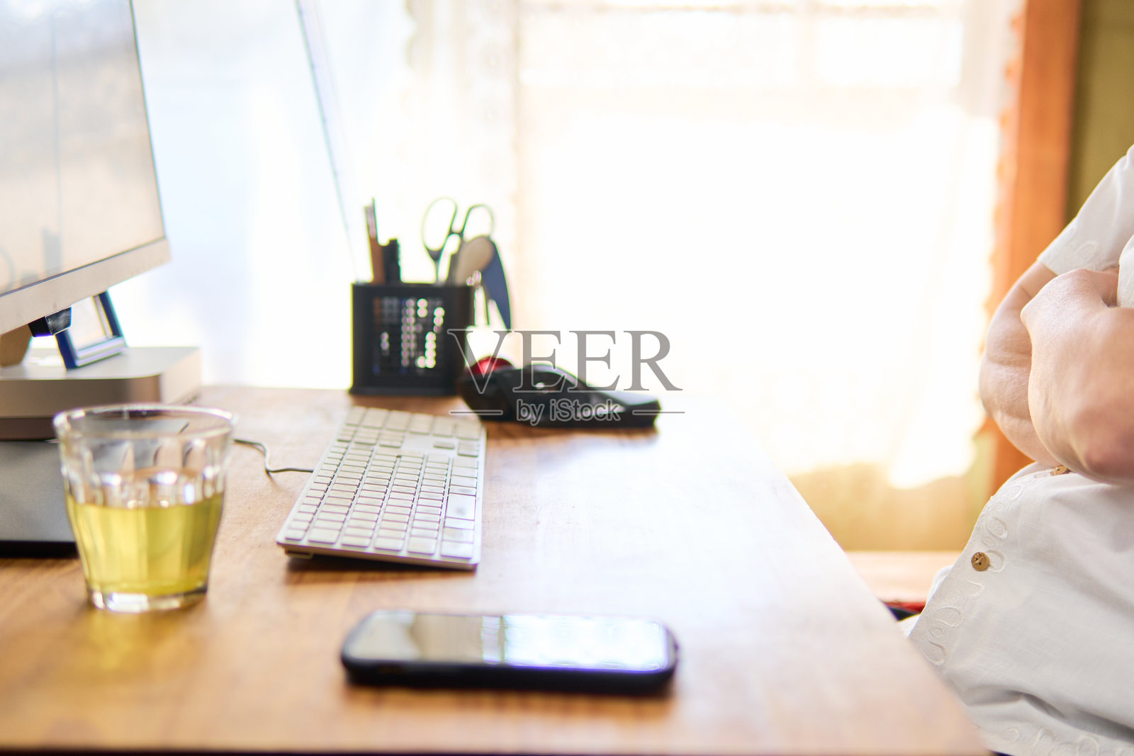 一位五十多岁的男子双臂交叉，专注地盯着电脑屏幕，沉思不已。照片摄影图片