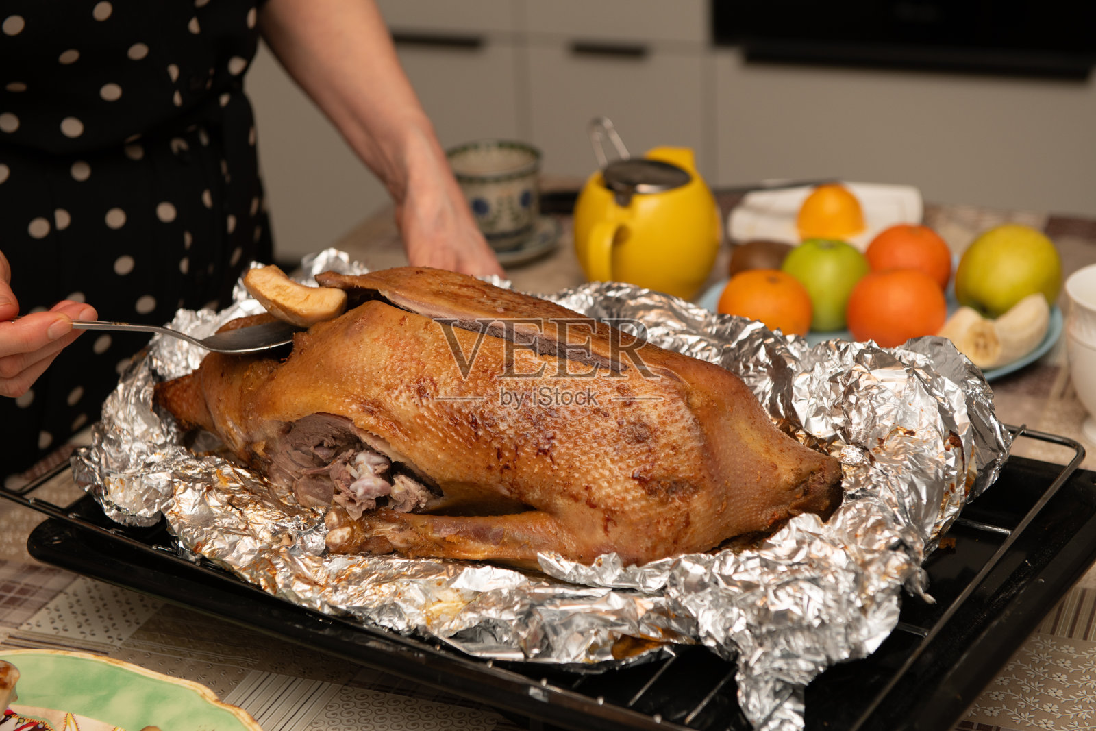 女人为圣诞晚餐端上烤鹅照片摄影图片