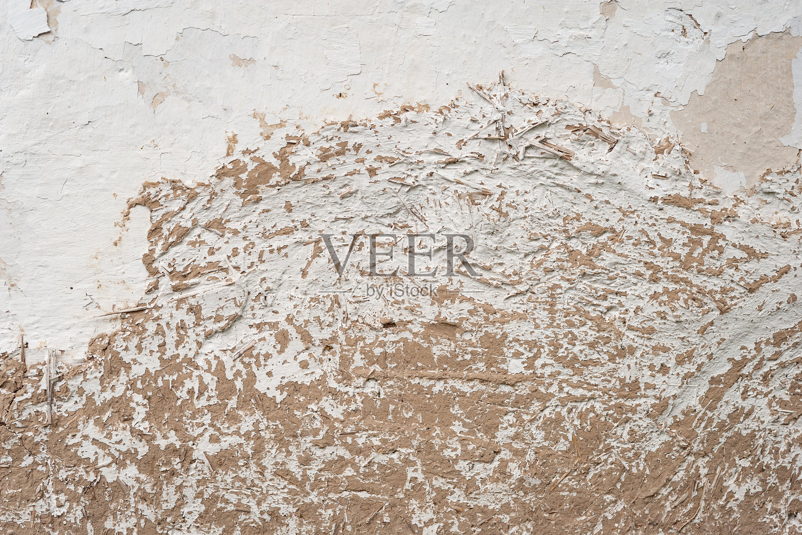 老旧的泥土墙。长长的裂缝。乡村房屋的破裂灰泥。照片摄影图片