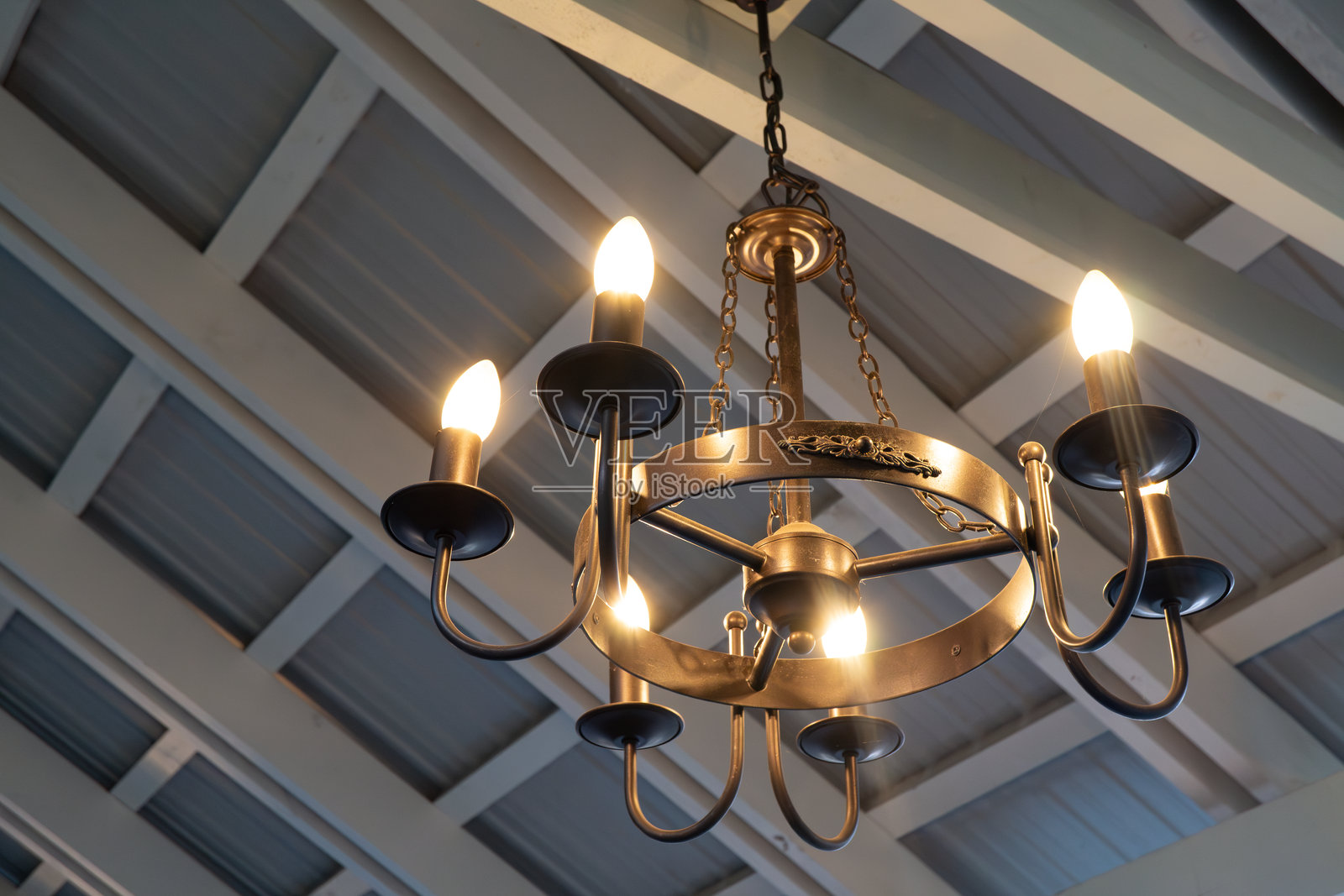 乡村风格的室内吊灯，温暖的灯光从木质天花板上悬挂下来照片摄影图片