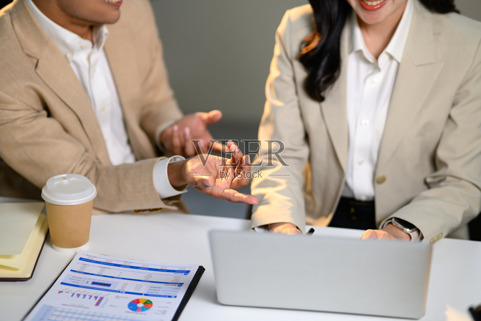 办公室同事在使用笔记本电脑时讨论项目细节的特写镜头照片摄影图片