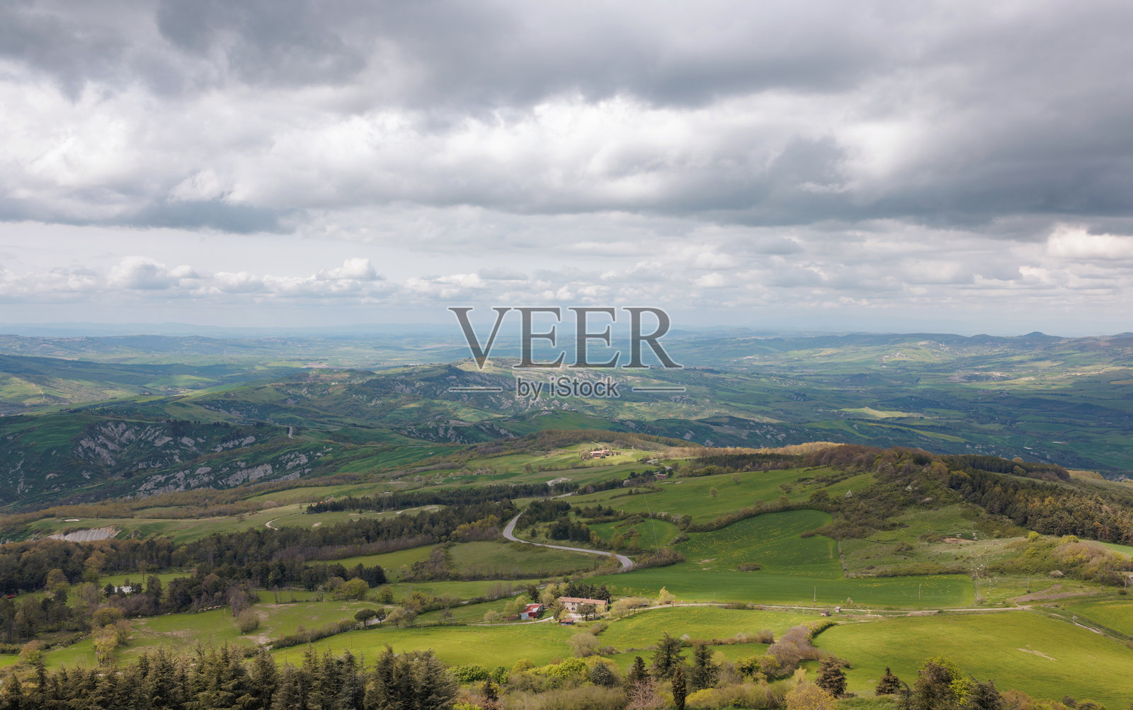 春天阴云密布下的起伏绿丘照片摄影图片