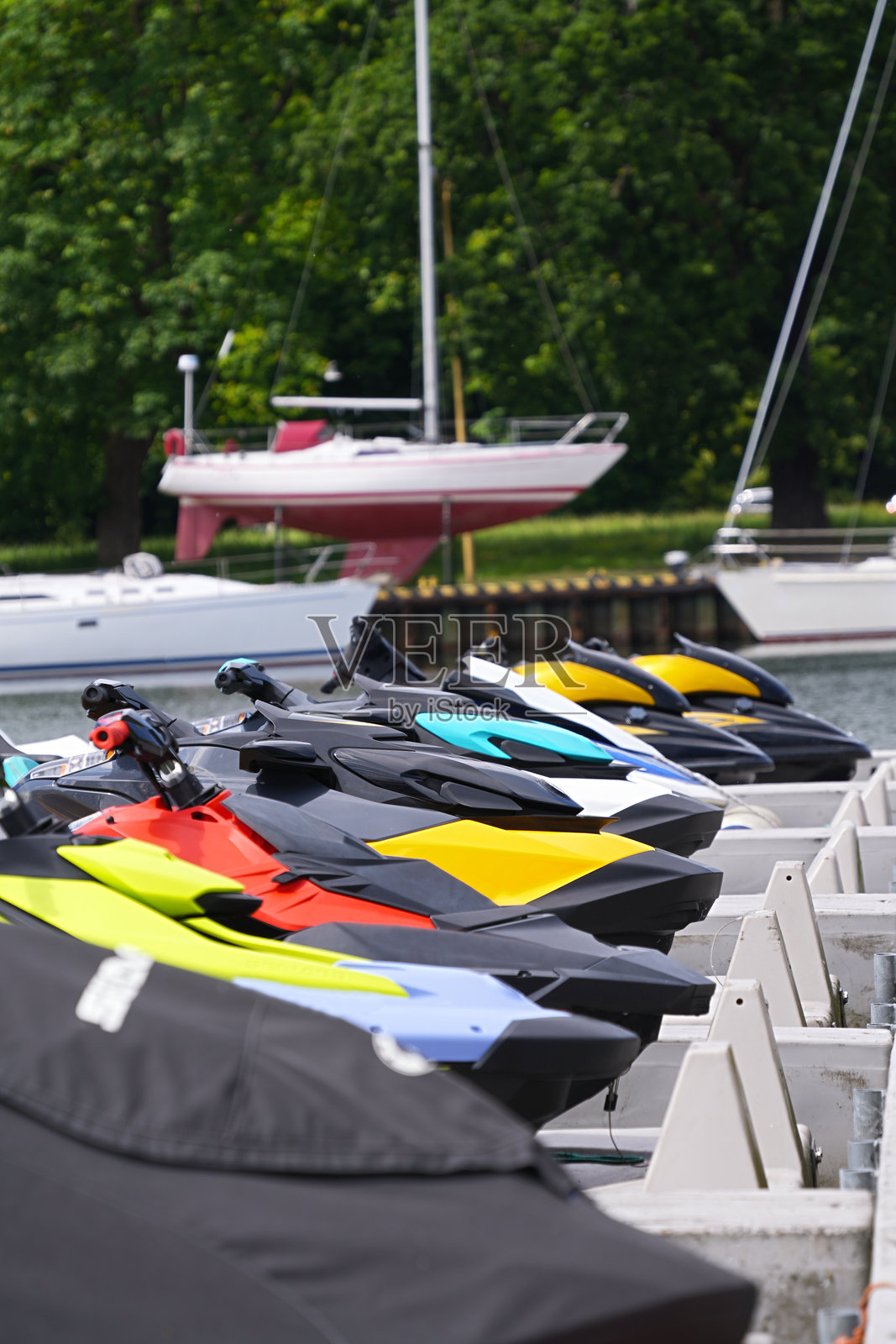 五彩缤纷的水上摩托和船只停靠在海码头照片摄影图片