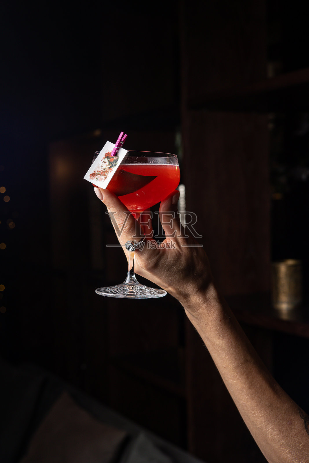 女性手握着一杯红色鸡尾酒照片摄影图片